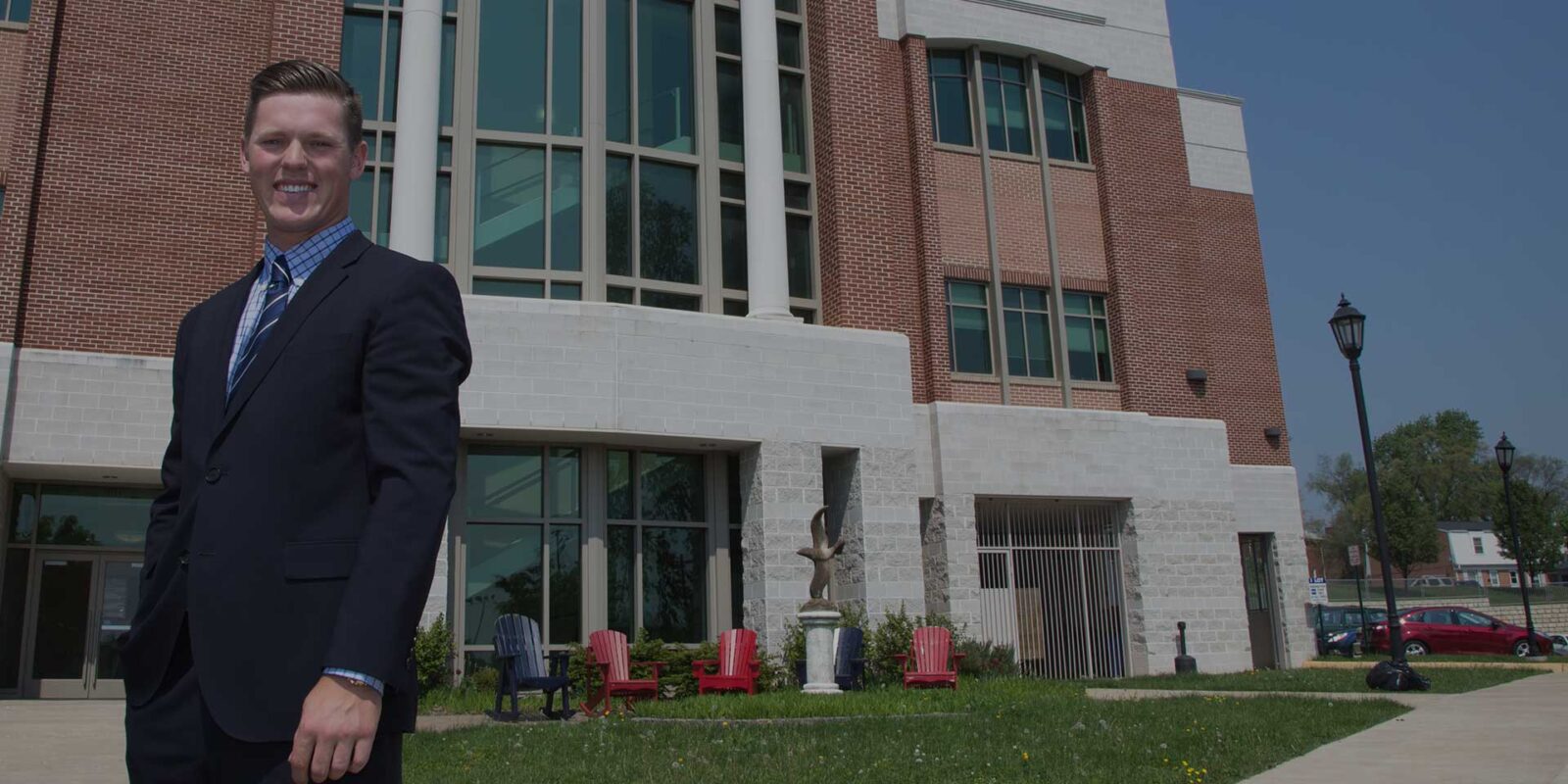 su_mba_hero Student of online MBA at Shenandoah University standing outside campus building
